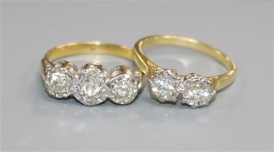An 18ct gold and two stone illusion set diamond ring and a yellow metal and three stone illusion set diamond ring.